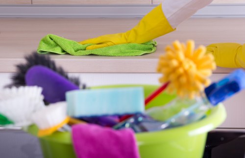 Professional cleaner maintaining desks and shared office spaces in Harringay
