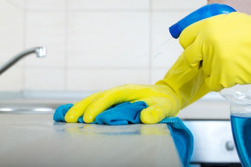 Cleaner preparing a short-let kitchen and living area in Harringay
